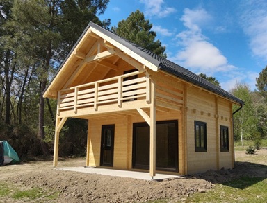 Chalet en bois habitable avec mezzanine et terrasse install� dans un jardin